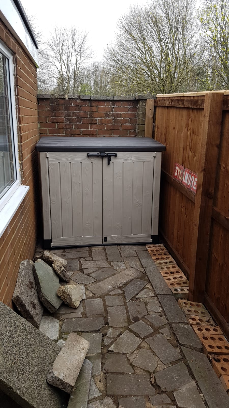 New close-boarded fence running down a narrow side path beside a house